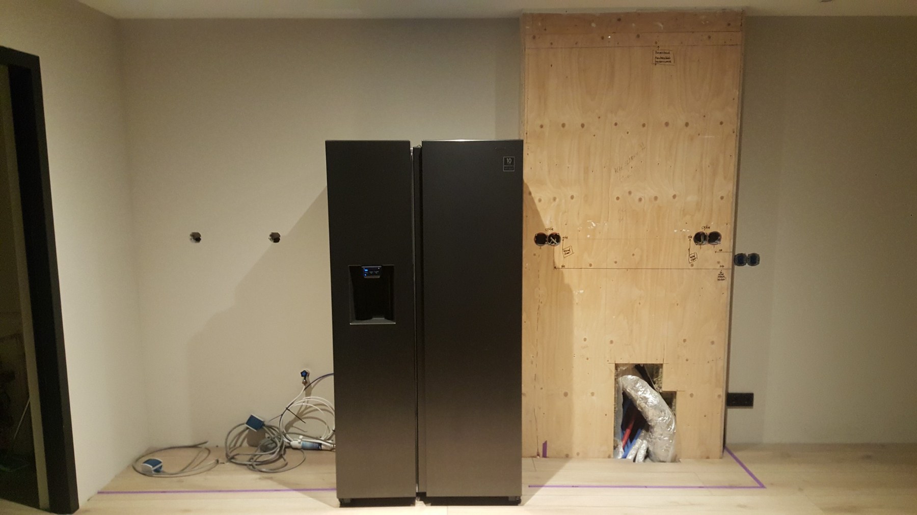 Voorbereide elektrische aansluitpunten rond de koelkast en keukenwand